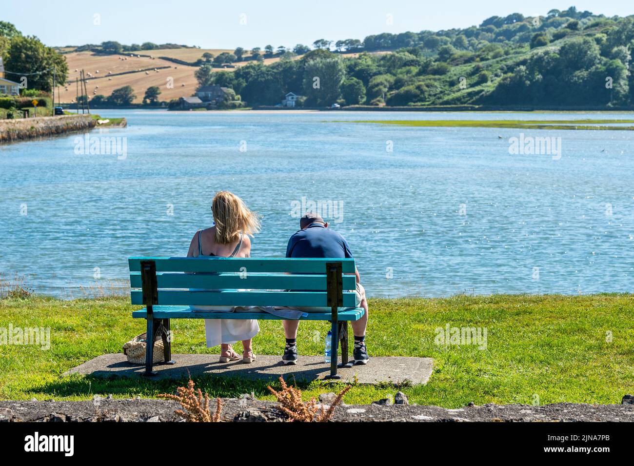 Rossarbery, West Cork, Irland. 10. August 2022. Ein Paar sitzt heute Nachmittag auf einer Bank in Rosscarbery, als die Temperaturen 24C Grad erreichten und sengende Sonne aufging. Met Éireann hat für dieses Wochenende eine Hitzewelle mit Temperaturen prognostiziert, die 29C erreichen wird. Quelle: AG News/Alamy Live News Stockfoto