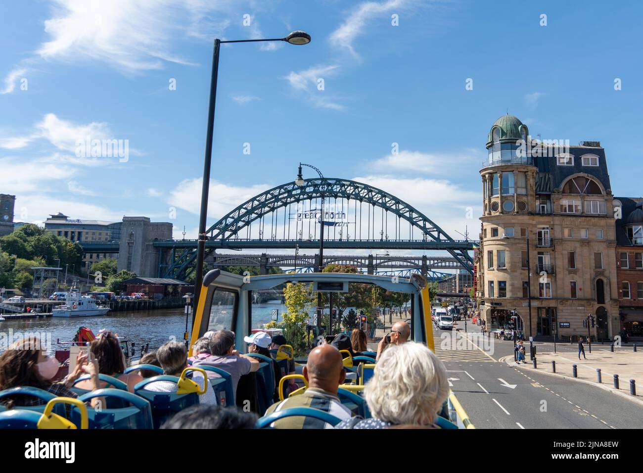 Reisen Sie durch die Stadt Newcastle Upon Tyne, Großbritannien, mit dem offenen Toon Tour Sightseeing Bus, an einem sonnigen Tag. Blick auf den Tyne Bridge Quayside. Stockfoto
