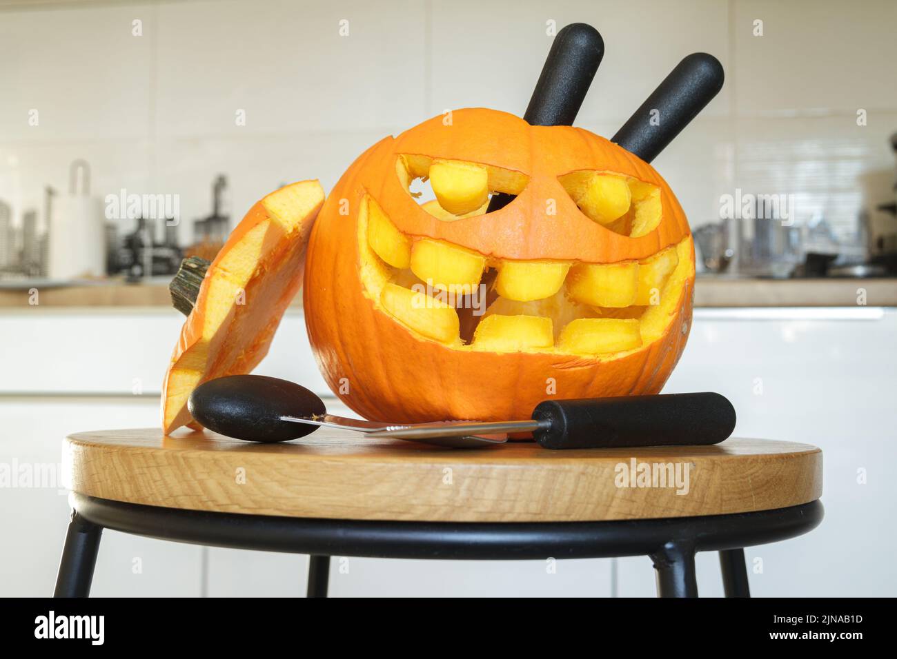 Geschnitzter Halloween Kürbis, Jack Laterne (Jack-o'-Laterne), mit Schnitzwerkzeugen. Gruselig lachend, beängstigender Kopf. Stockfoto