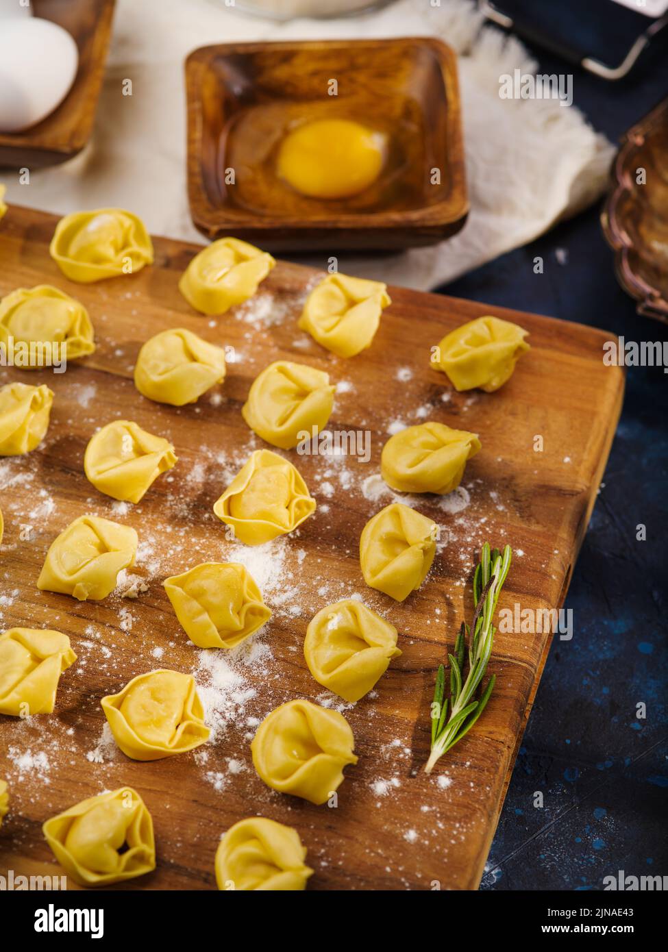 Nahaufnahme. Hausgemachte rohe Knödel auf einem Holzschneidebrett, das fertig zum Kochen ist. Hausgemachte Rezepte für Knödel, Ravioli gefüllt mit Hackfleisch. Dort Stockfoto