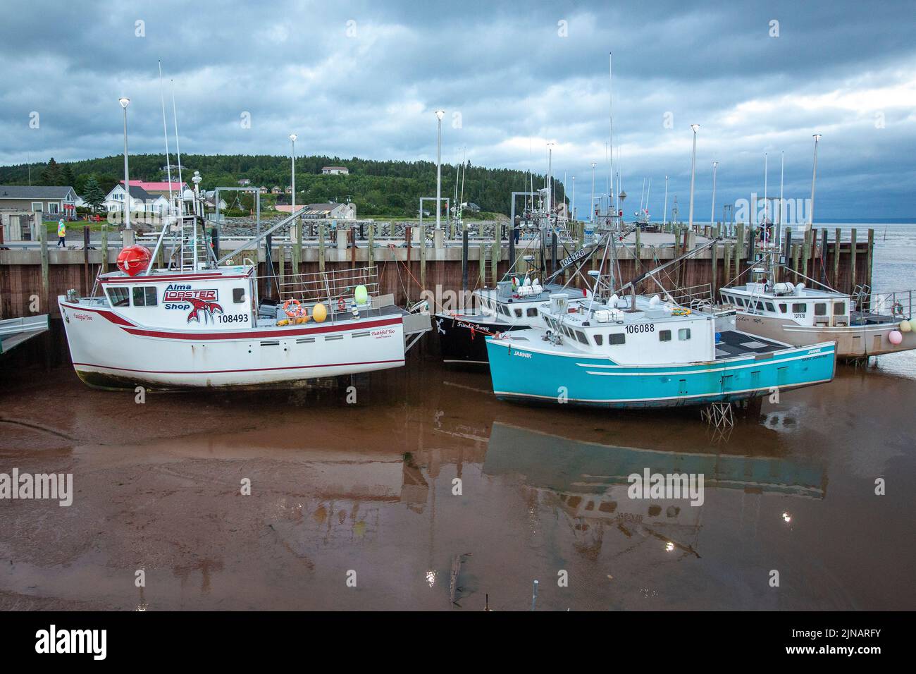 Am Mittwoch, den 6. Juli 2022, sitzen im Hafen von Alma, New Brunswick, Hummer-Fischerboote auf dem Meeresboden. Stockfoto