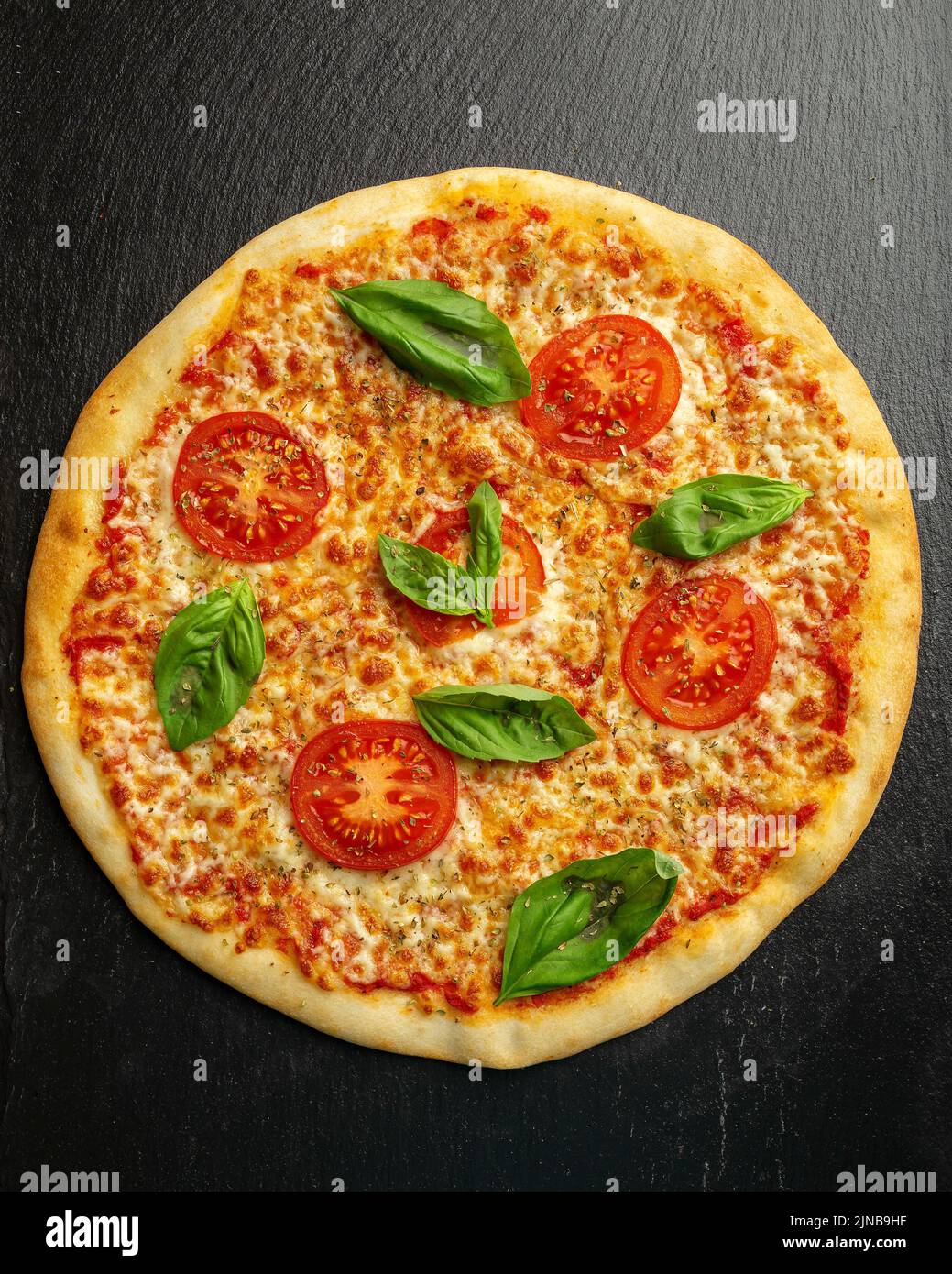 Ganze Pizza auf dem Tisch mit Zutaten, Draufsicht Stockfoto