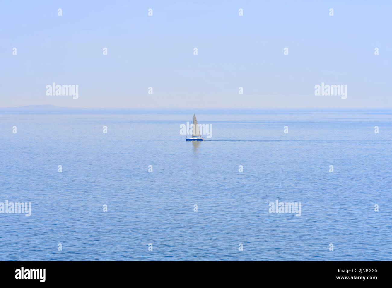 Das einsame Segelboot am Horizont im Meer. Stockfoto