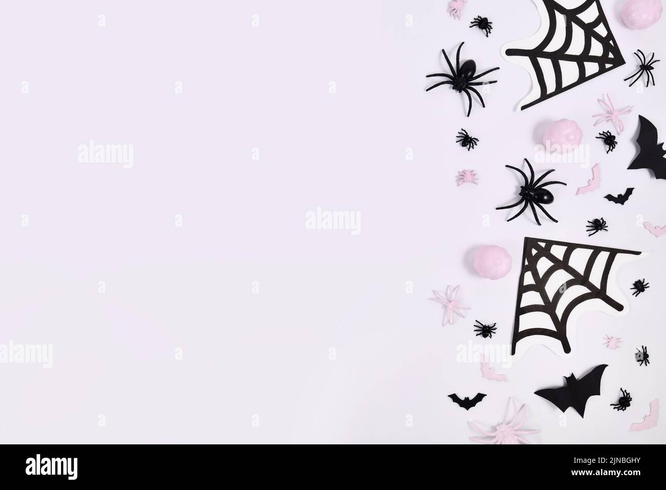 Rosa und schwarze Halloween Dekoration auf der Seite von weißem Hintergrund mit Kopierraum Stockfoto