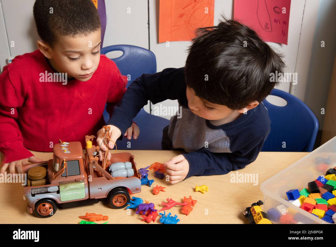 Bildung Vorschule Kinderbetreuung 3-Jährige Finale in Serie Jungen spielen zusammen mit Spielzeug nach Konfliktlösung Prozess #7 in Serie Stockfoto