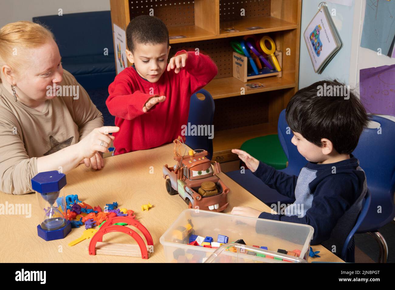 Bildung Vorschule 3-jährige zwei Jungen Konflikt um Spielzeug, Lehrer arbeitet mit Kindern, um Konflikt zu lösen, Lehrer bekräftigt Problem #4 in Serie Stockfoto