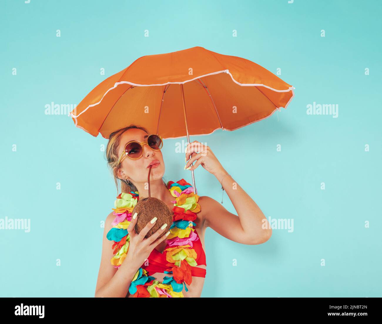 Frau bedeckt sich von der Sonnenstrahlung mit einem Regenschirm Stockfoto