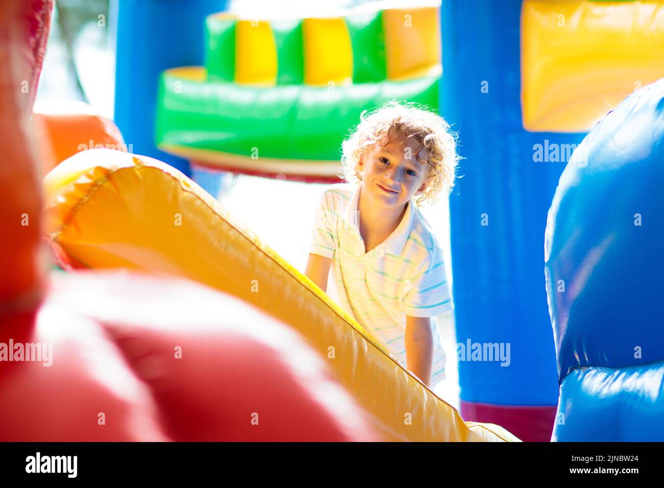 Kinder springen auf buntem Spielplatz-Trampolin. Kinder springen in aufblasbare Sprungburg auf Kindergarten Geburtstagsparty Stockfoto