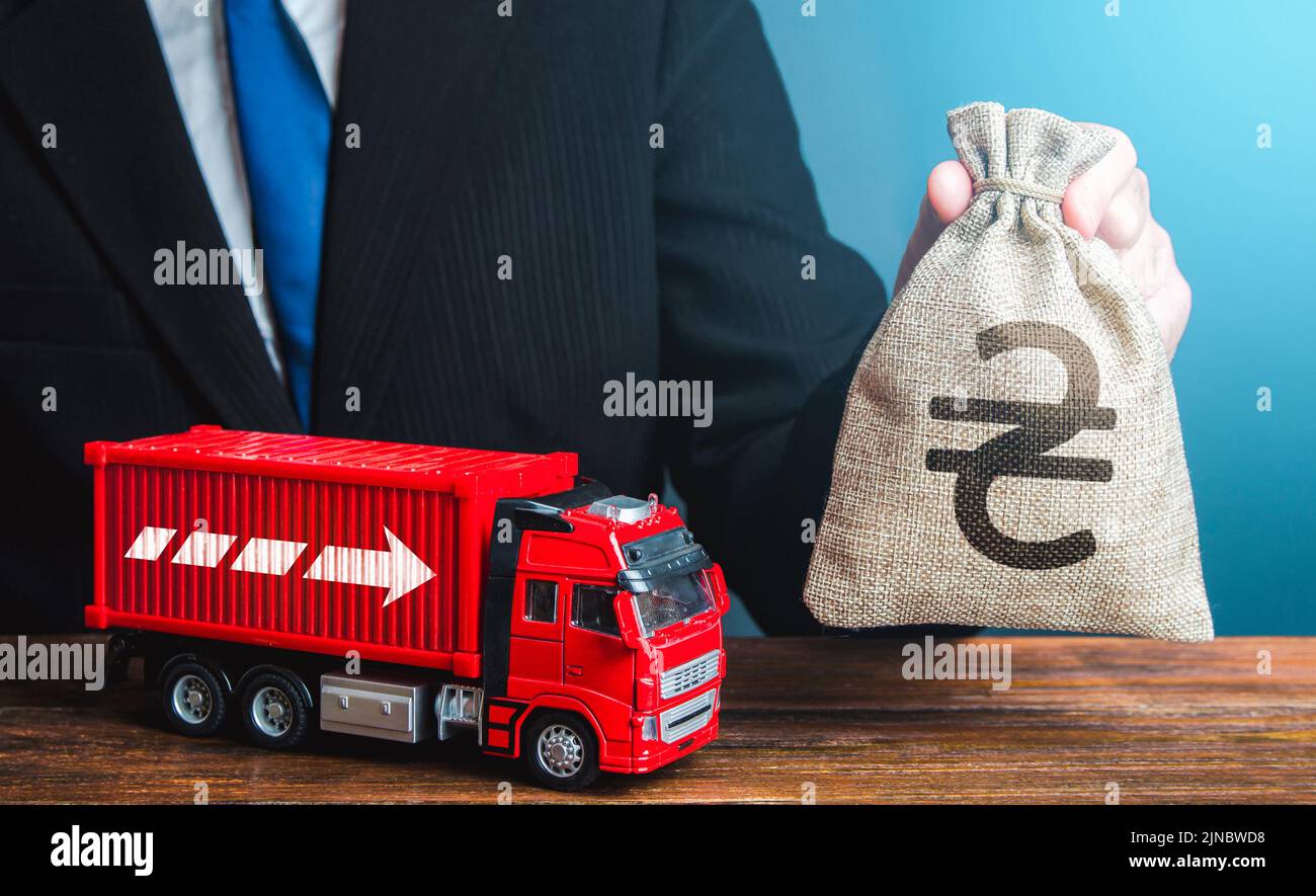 Geschäftsmann mit ukrainischen Griwna Geldbeutel und LKW. Einnahmen aus dem Transportgeschäft und dem Güterverkehr. Hohe Gehälter für Fahrer. Steigende pri Stockfoto