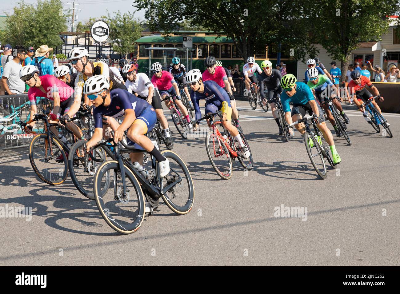 Radfahrer im Peloton, die eine Runde des Criterium fahren, ein Radrennen, bei dem die Radfahrer auf einer Rennstrecke in Bowness Calgary, Kanada, fahren Stockfoto