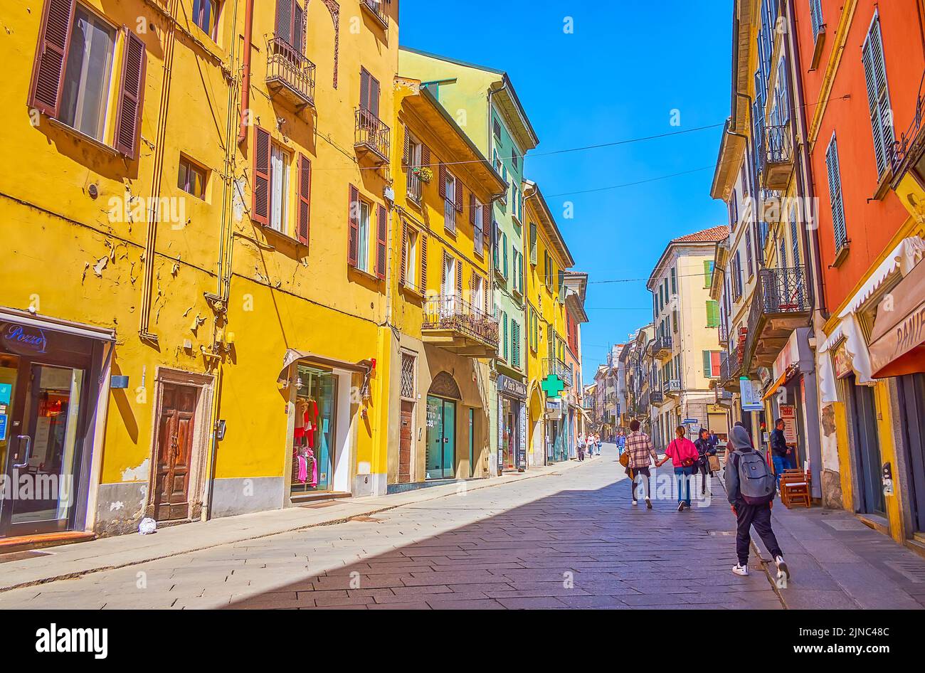 PAVIA, ITALIEN - 9. APRIL 2022: Die Straße Strada Nuova hat zahlreiche historische Häuser entlang der Straße, die im Erdgeschoss mit beliebten Boutiquen besetzt ist Stockfoto