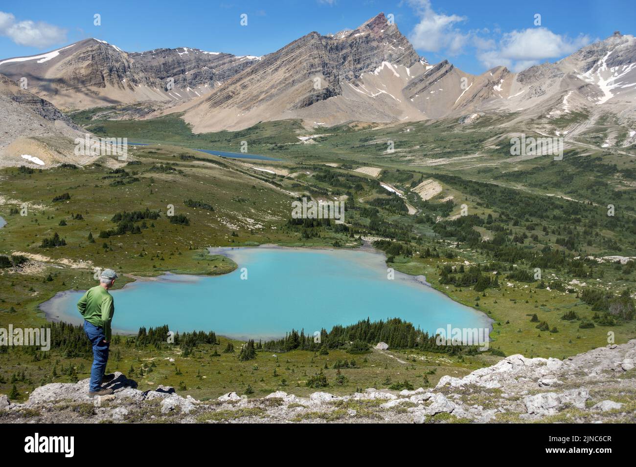 Isolierter Wanderer Blick auf die alpine Landschaft Teal gefärbter See und Rocky Mountain Peaks Skyline. Sonniger Tag Malerische Sommerzeitwanderungen Banff National Park Kanada Stockfoto