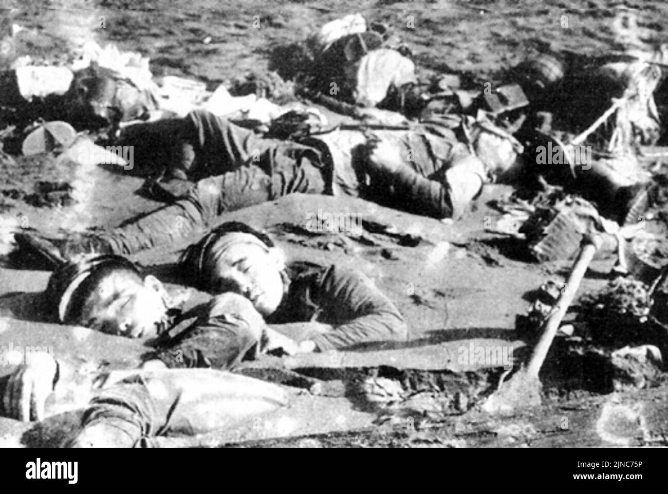 Die Leichen japanischer Soldaten, die nach der Schlacht am Tanaru-Fluss, Guadalcanal, 21. August 1942 teilweise durch die Meeresströmung im Sand begraben wurden Stockfoto