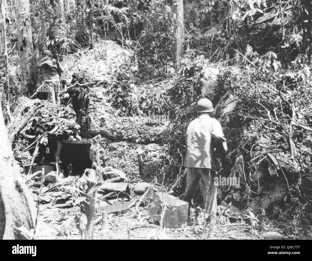 Nach der Schlacht am 3. November während der Matinakau-Offensive, die eine Schlacht bei der Guadalcanal-Kampagne war, überprüfen zwei US-Marineinfanteristen einen japanischen Korallenblockbunker in der Nähe von Point Cruz. Stockfoto