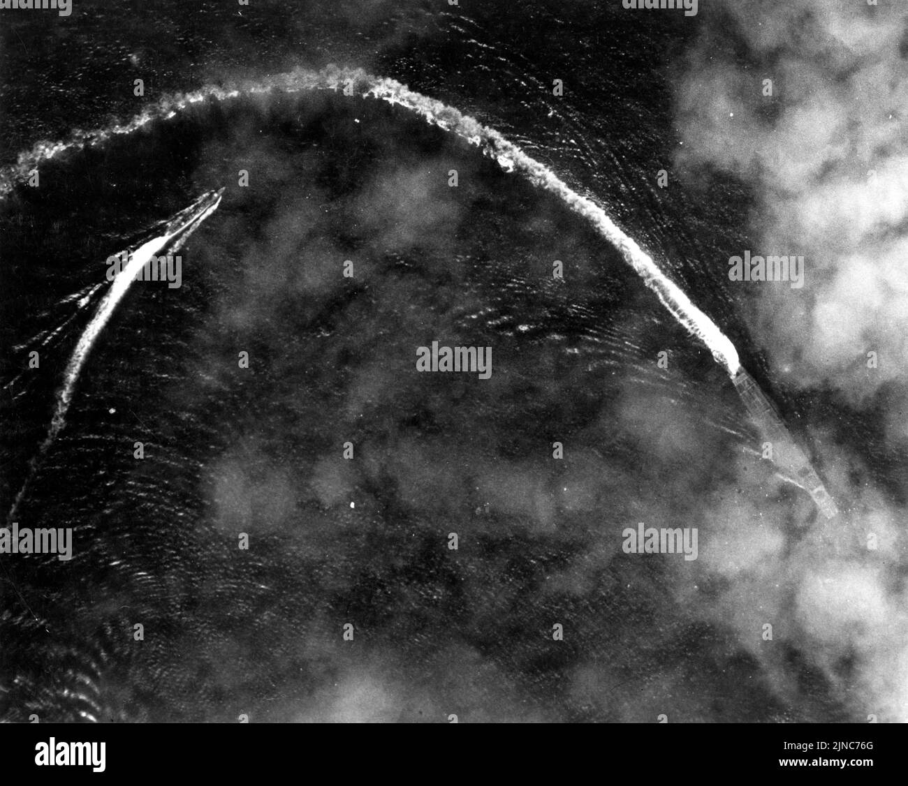 Akagi (rechts, teilweise von Wolken verdeckt) ergreift Ausweichmanöver während eines Luftangriffs der US B-17s kurz nach 08:00 am 4. Juni 1942. Das nachlaufende Schiff links ist wahrscheinlich der Flugzeugarderzerstörer des Trägers, Nowaki. Das Foto wurde von einer der angreifenden B-17s aufgenommen Stockfoto