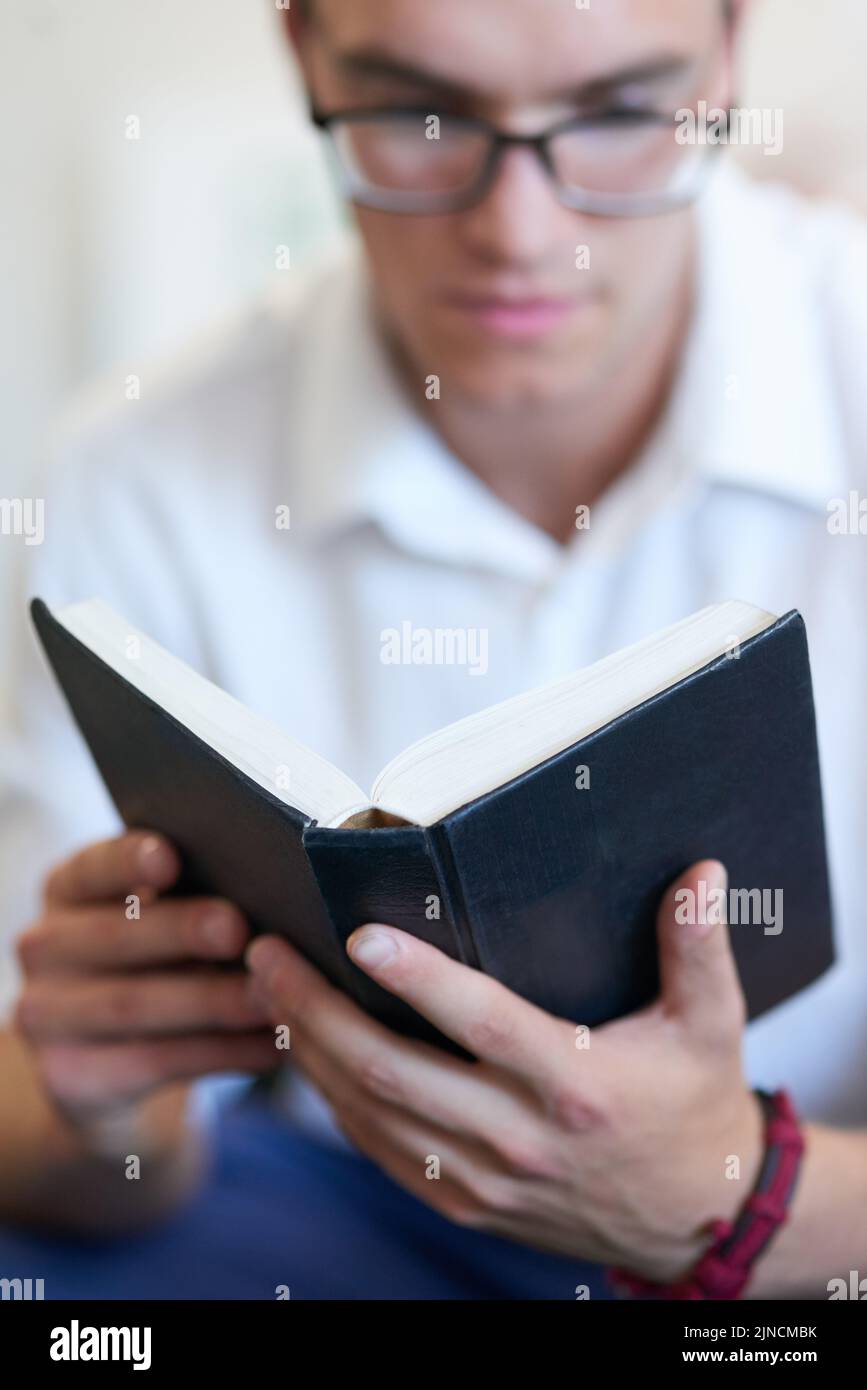 Finden Sie immer Zeit, sich mit Ihren Überzeugungen zu verbinden. Ein hübscher junger Geschäftsmann liest seine bibel bei der Arbeit. Stockfoto