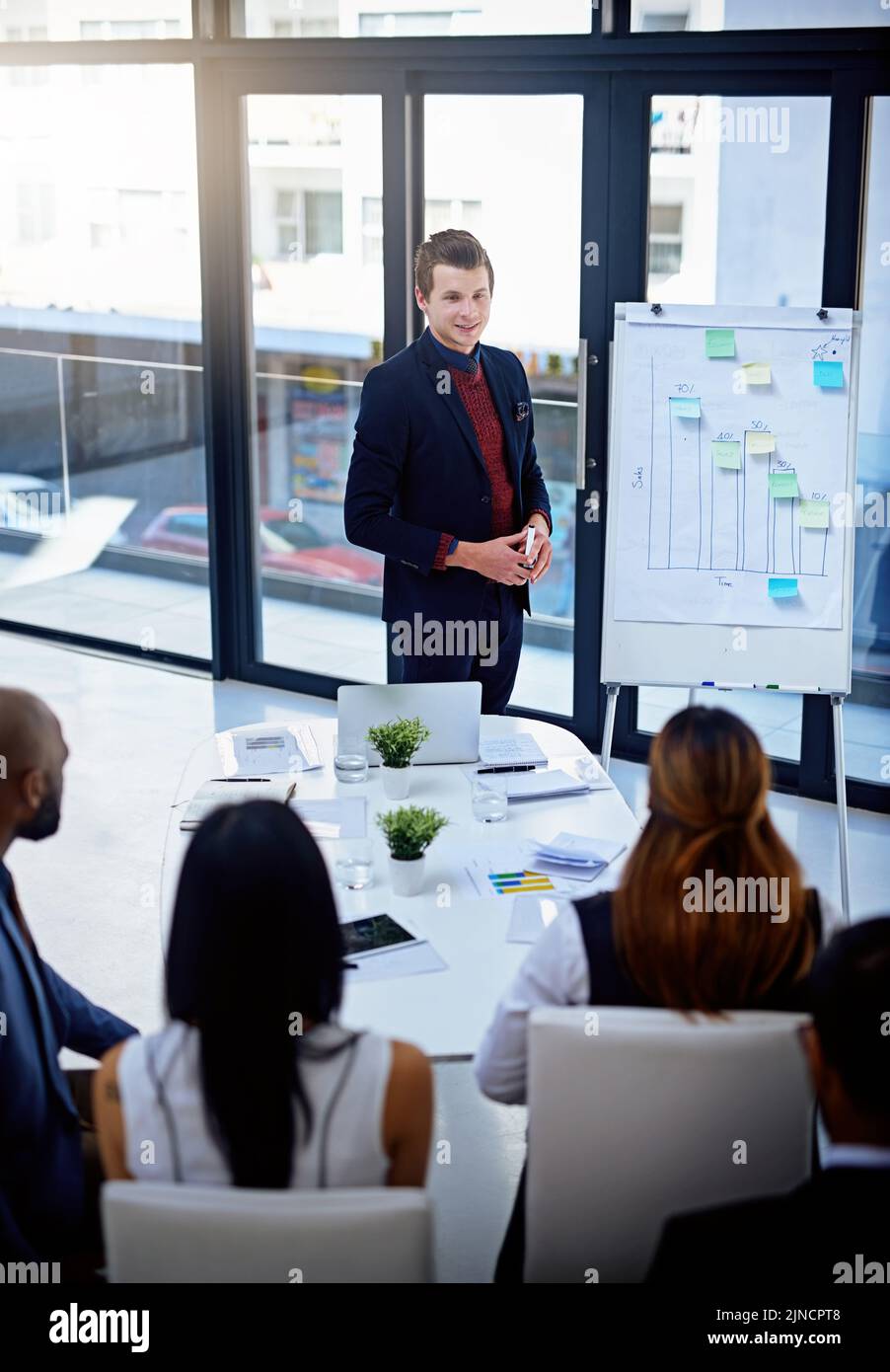 Eine gute Vorbereitung gibt Ihnen immer das zusätzliche Vertrauen. Ein junger Geschäftsmann gibt eine Demonstration auf einem Whiteboard zu seinen Kollegen in einem modernen Stockfoto