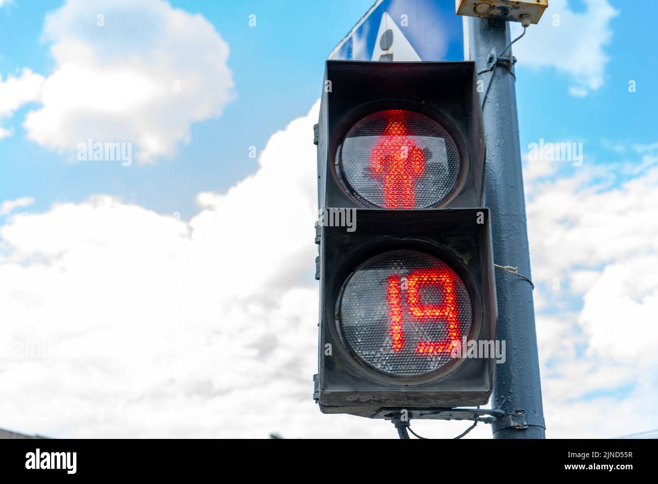 Rote Ampel für Fußgänger auf dem Hintergrund des blauen Himmels. Rote Nummer 19 an der Ampel. Platz zum Schreiben, Platz zum Kopieren. Stockfoto