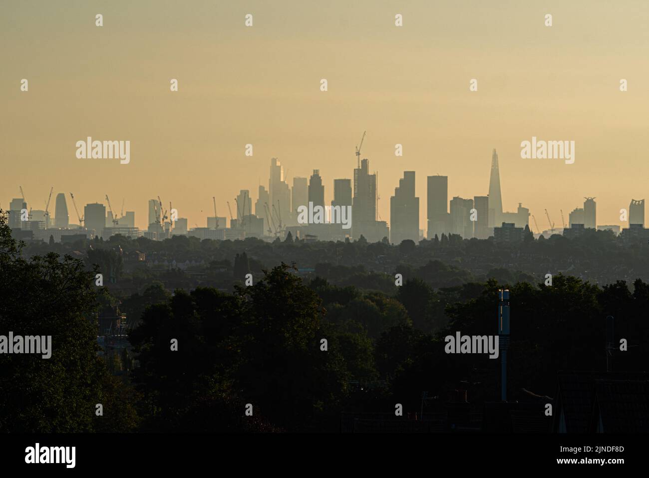 Wimbledon London, Großbritannien. 11 August 2022 . Die Skyline der Stadt London und des Finanzdistrikts glüht bei Sonnenaufgang in der Morgensonne, da die Temperaturen heute auf 35celsius steigen werden, nachdem das Met-Büro einen bernsteinfarbenen Wärmemalert ausgegeben hat und dass London nach den Grafschaften Kent und bald unter ein Rohrleitungsverbot gestellt werden könnte Sussex hatte früher ein Verbot vom 12.. August ausgesprochen. Infolge der Brände im Großraum London während der Hitzewelle stieg die gefährliche Luftverschmutzung an. Kredit. amer Ghazzal/Alamy Live Nachrichten Stockfoto