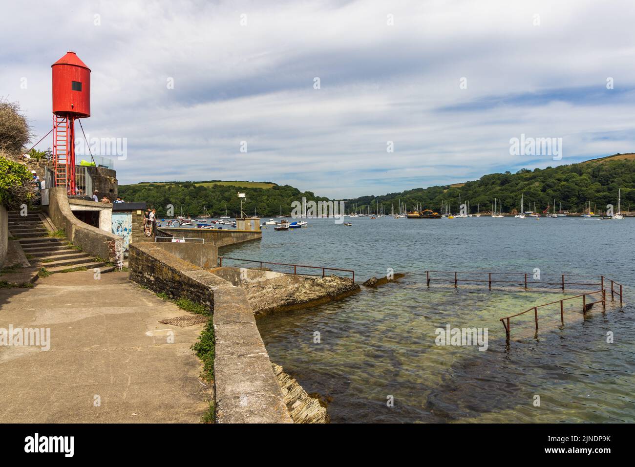 Der hellrote Whitehouse Point Leuchtturm bei Fowey Landing, mit dem alten Meerpool auf der rechten Seite, Cornwall. Stockfoto