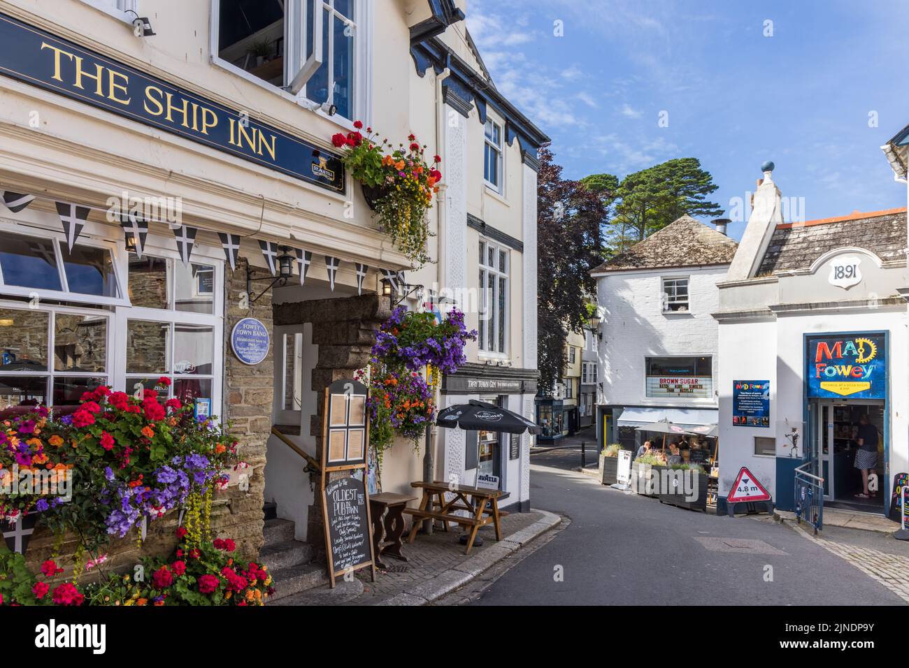 Eine Straßenszene mit farbenfrohen Blumenmotiven vor dem 16. Century Ship Inn, einem historischen Pub in Fowey, Cornwall. Stockfoto