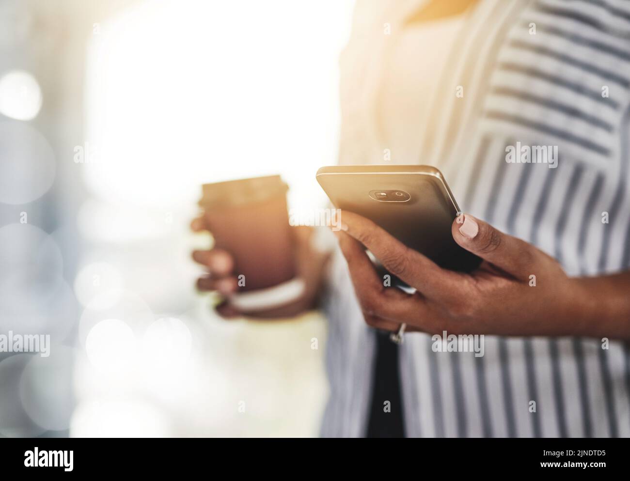 Nahaufnahme einer legeren Geschäftsfrau, die ein Telefon für die Kommunikation mit Kunden verwendet, während sie von zu Hause aus mit Lichtreflexen arbeitet. Professionelle schwarze Hündin Stockfoto