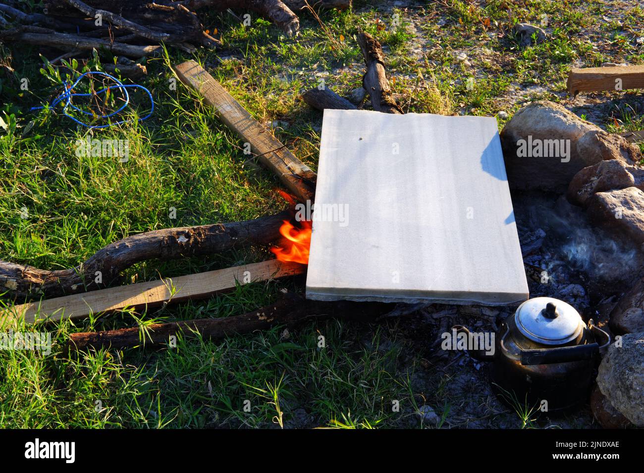 Marmor auf Lagerfeuer zum Kochen und Teekannen am Feuer im Freien Stockfoto