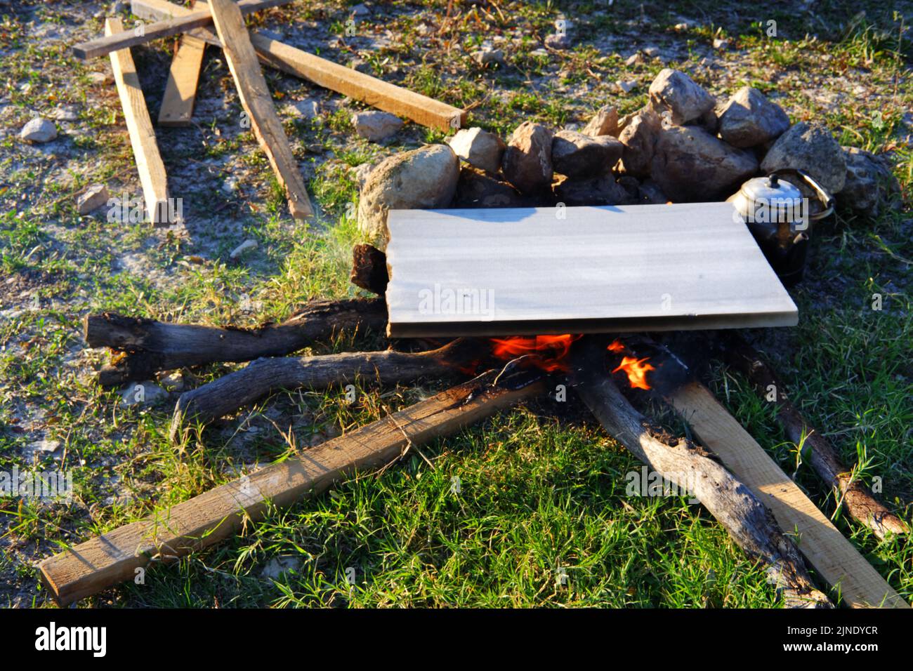Marmor auf Lagerfeuer zum Kochen und Teekannen am Feuer im Freien Stockfoto