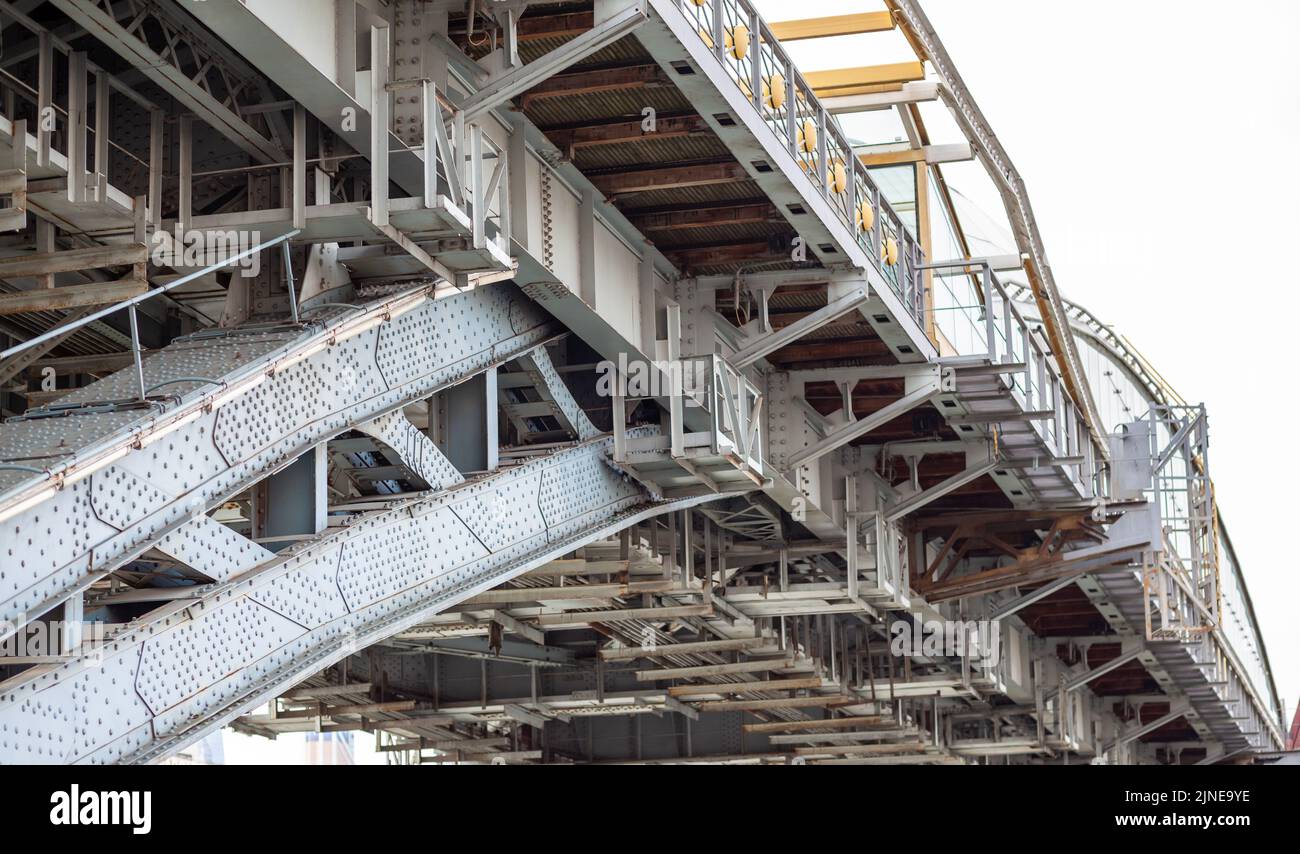 Metallstangen Fußgängerbrücke mit vielen Nieten. Kraftvolle Eisenbrücke, Blick von unten große Eisenniete. Ein Fluss fließt unter dem Br Stockfoto