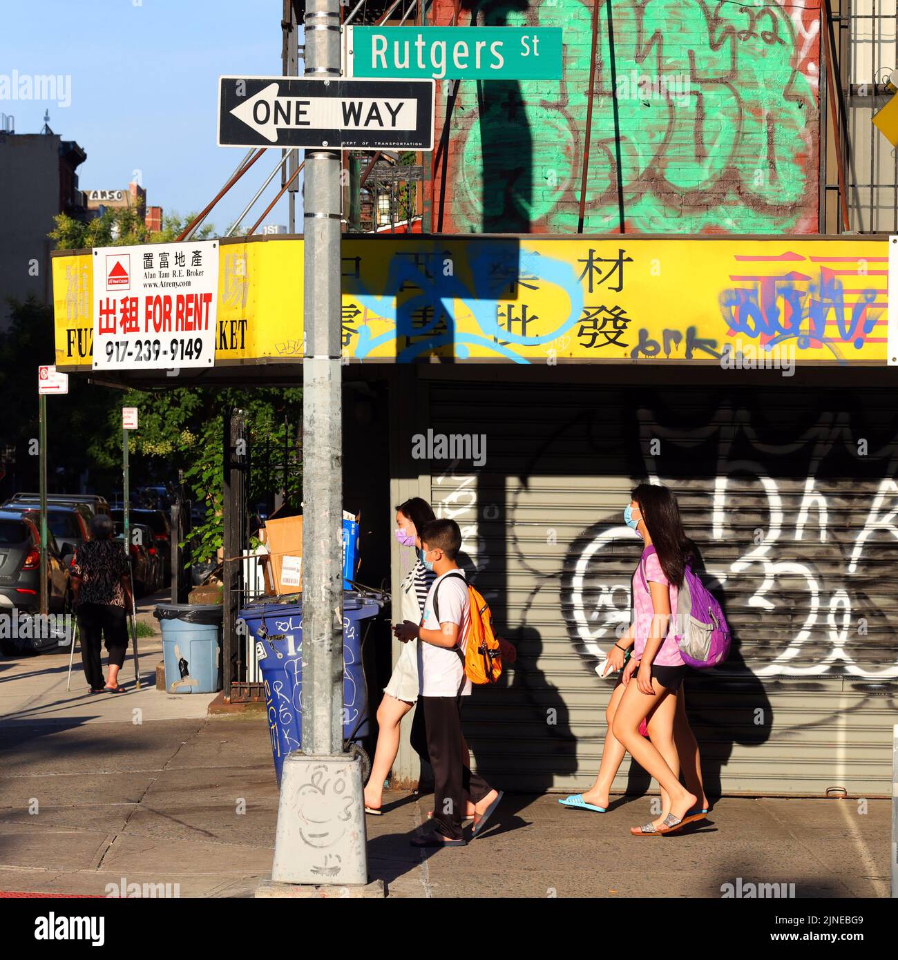 Chinesische Amerikaner gehen in der Nähe der Ecke Rutgers Street und Henry Street in Manhattan Chinatown, Lower East Side, New York City. Stockfoto
