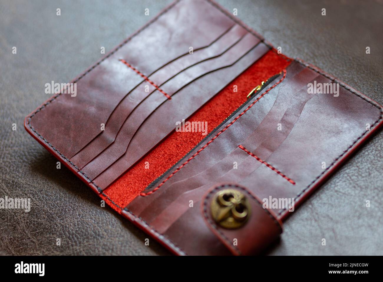 Weibliche braune Leder offene Geldbörse auf Leder-Hintergrund. Stockfoto