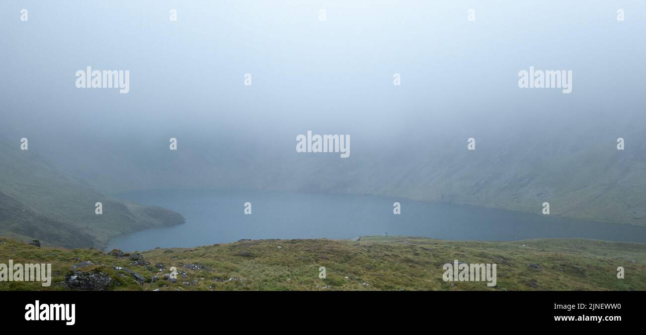 Cader Idris Berg mit See in der Nähe der Stadt Dolgellau, im Nationalpark Snowdonia in Wales, nebliger Morgen 2022. Stockfoto
