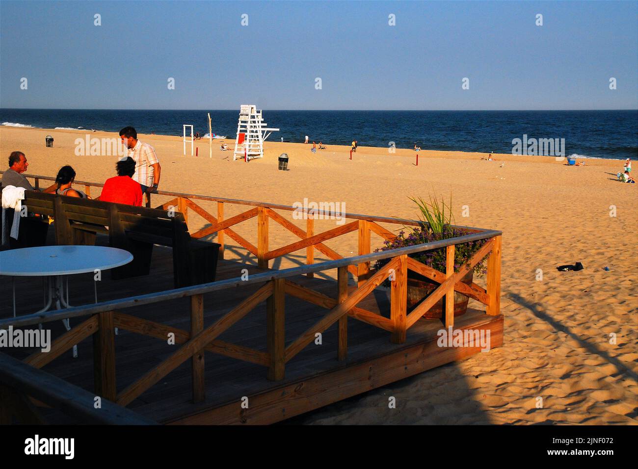 Am Ende eines Sommerurlaubs treffen sich Freunde auf einer Terrasse mit Blick auf den Main Beach in East Hamptons, einem der besten Strände in den Hamptons Stockfoto