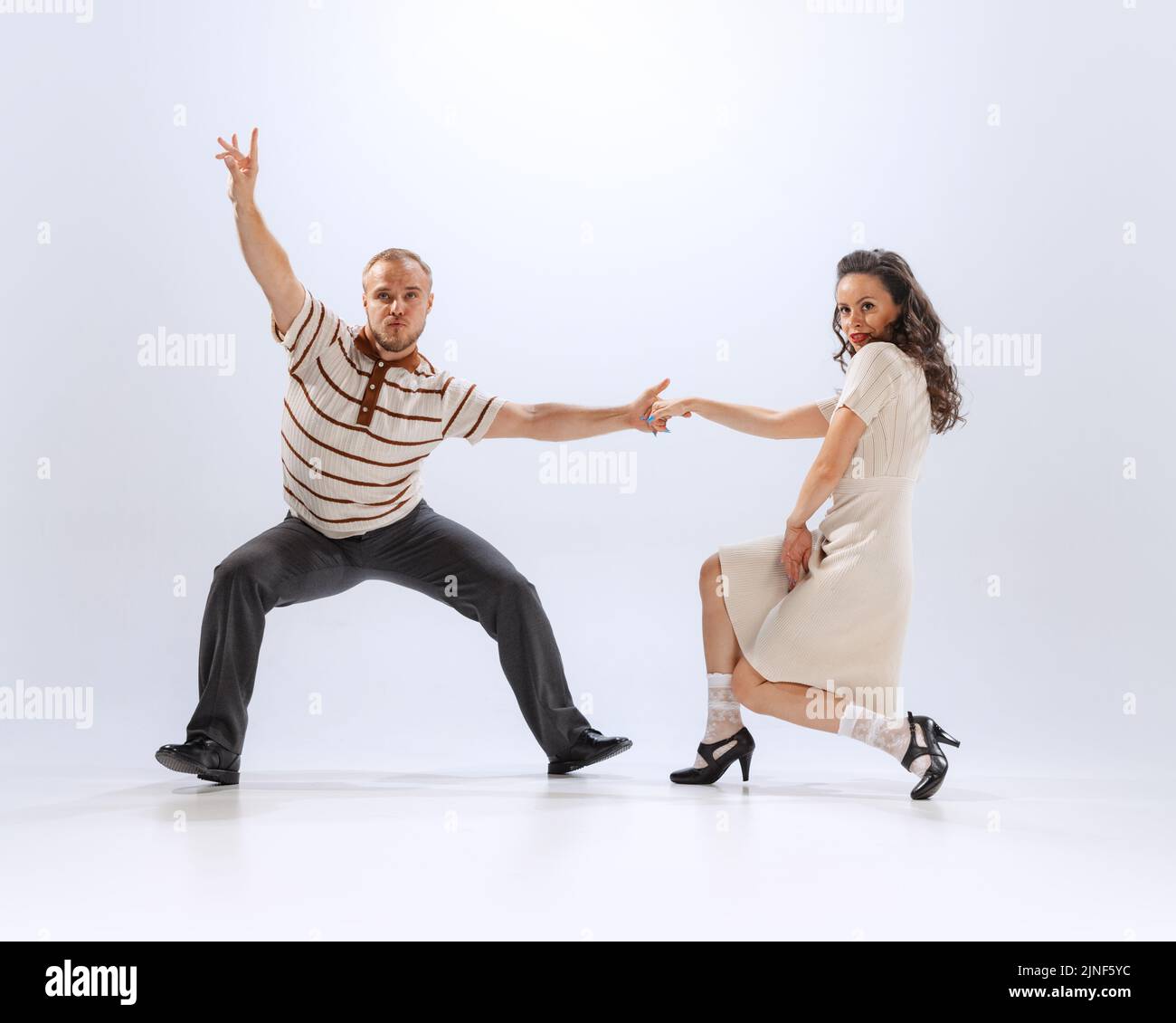 Dynamisches Porträt von emotionalen Mann und Frau tanzen Sporttänze isoliert auf weißem Hintergrund. 50s, 60s ,70s amerikanischer Mode-Stil. Stockfoto