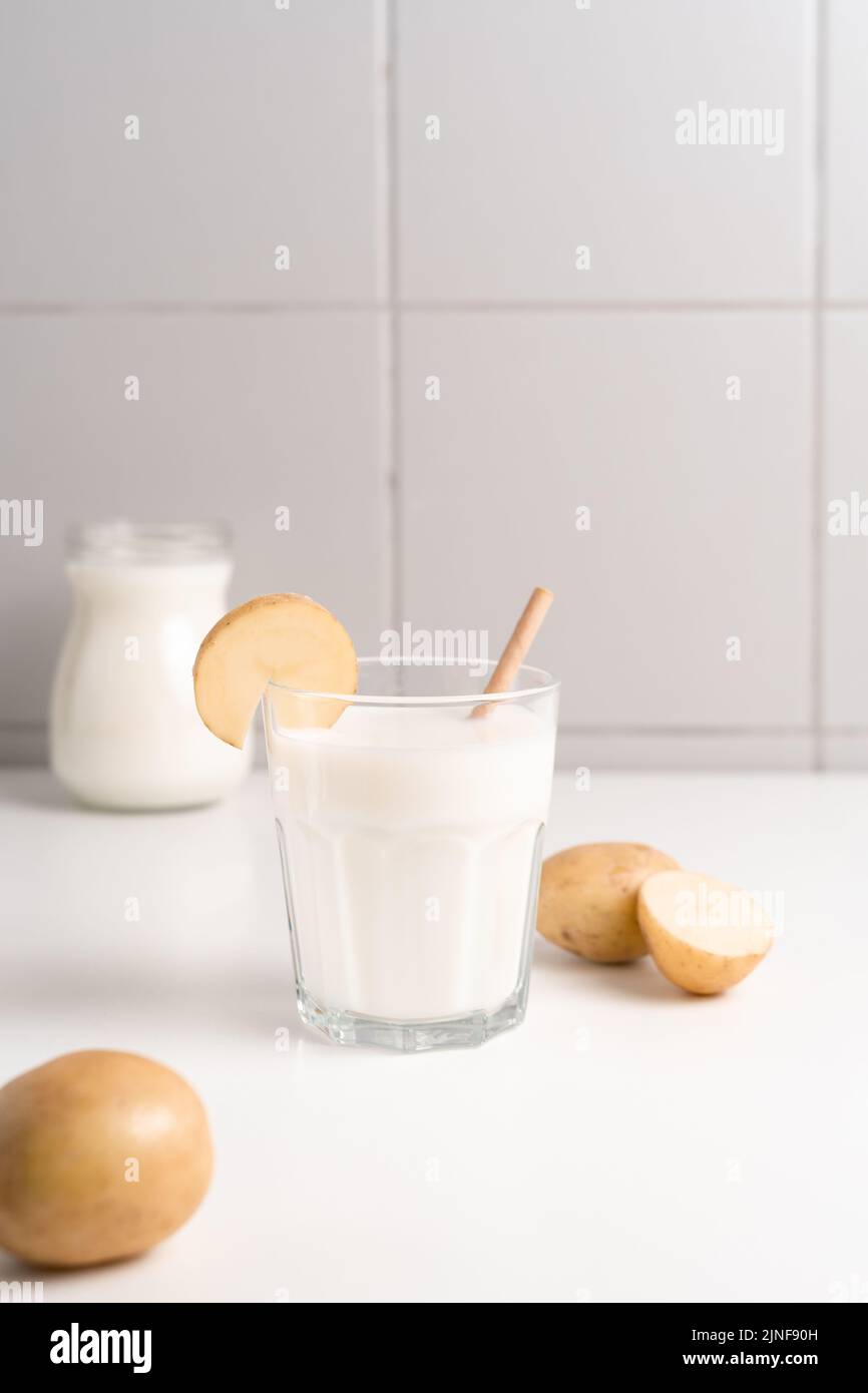 Ein Glas Kartoffelmilch auf dem Tisch. Alternative Milch Auf Pflanzlicher Basis Stockfoto