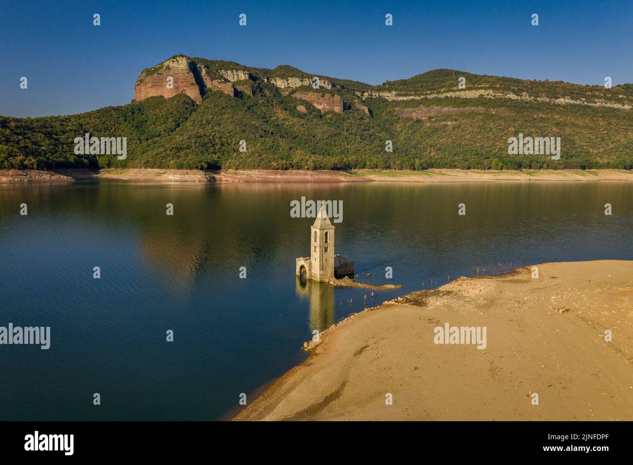 Luftaufnahme des Glockenturms von Sant Romà de Sau und des Sau-Stausees während der Sommertrockenheit von 2022 (Osona, Barcelona, Katalonien, Spanien) Stockfoto