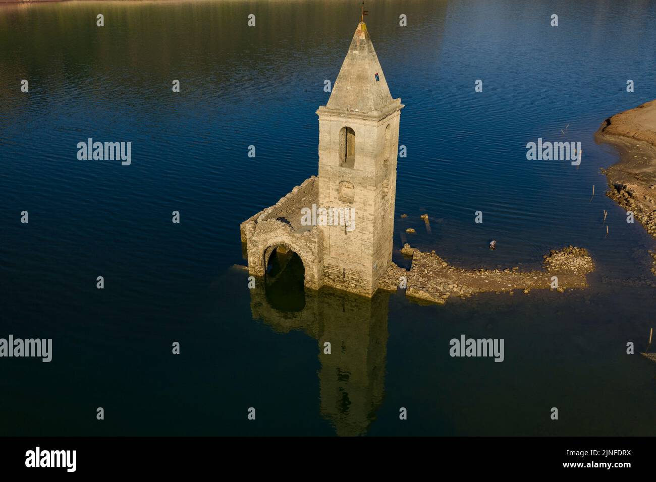 Luftaufnahme des Glockenturms von Sant Romà de Sau und des Sau-Stausees während der Sommertrockenheit von 2022 (Osona, Barcelona, Katalonien, Spanien) Stockfoto
