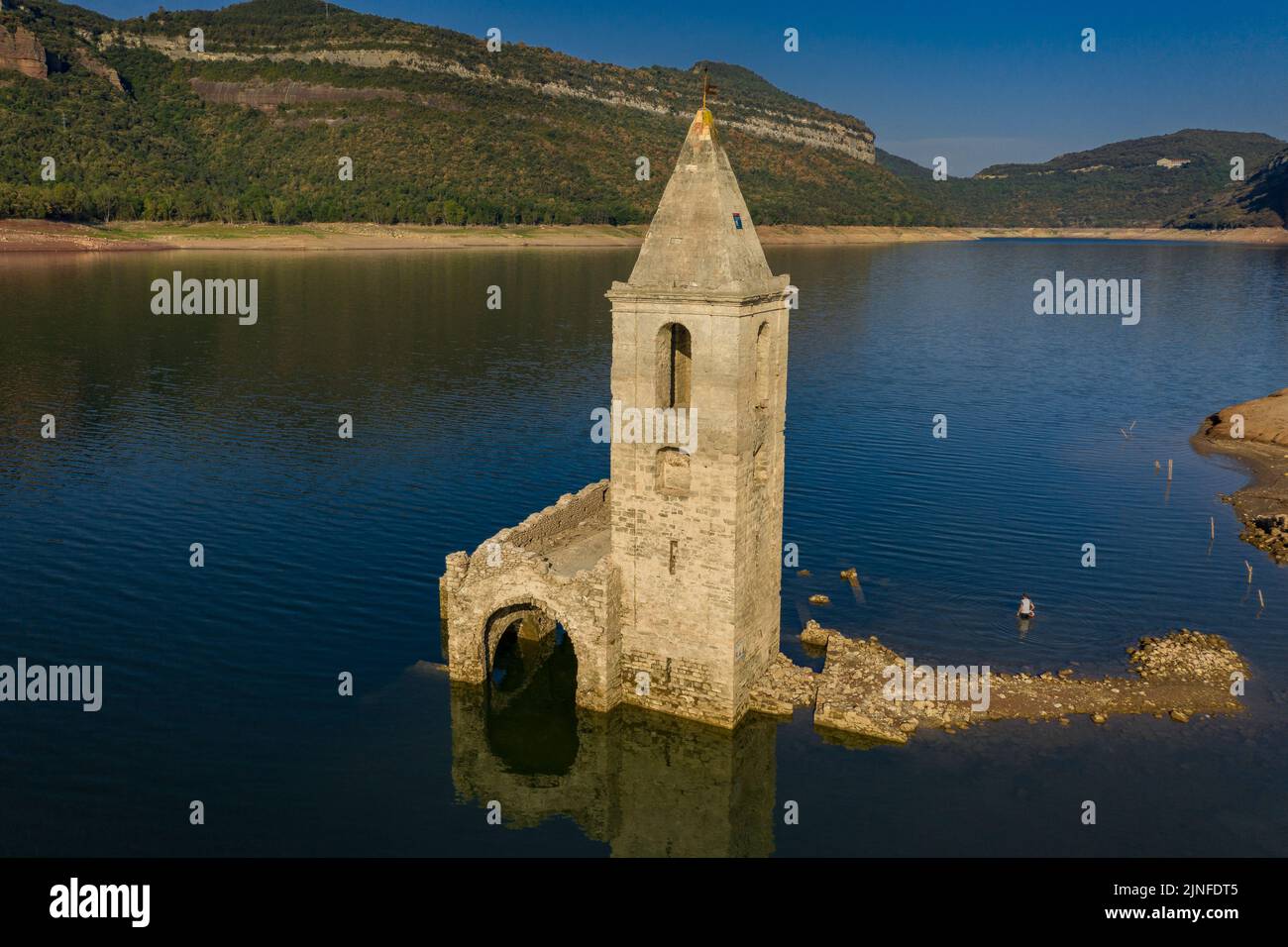 Luftaufnahme des Glockenturms von Sant Romà de Sau und des Sau-Stausees während der Sommertrockenheit von 2022 (Osona, Barcelona, Katalonien, Spanien) Stockfoto