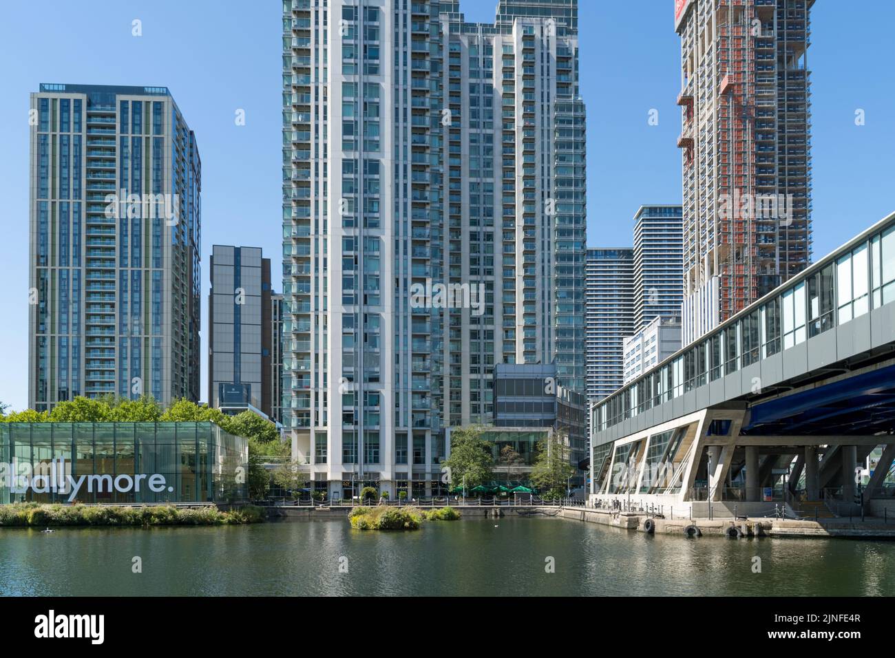 Pan Peninsula-Apartmentgebäude und andere Hochhäuser mit einem Verkaufsanzug-Würfel von Ballymore am Ufer der Docklands. London Stockfoto