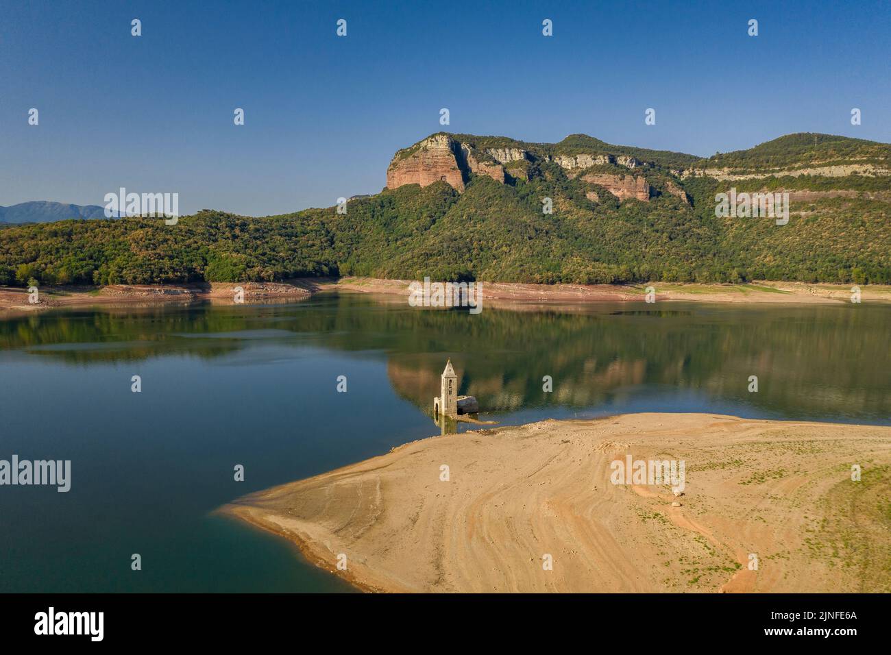 Luftaufnahme des Glockenturms von Sant Romà de Sau und des Sau-Stausees während der Sommertrockenheit von 2022 (Osona, Barcelona, Katalonien, Spanien) Stockfoto