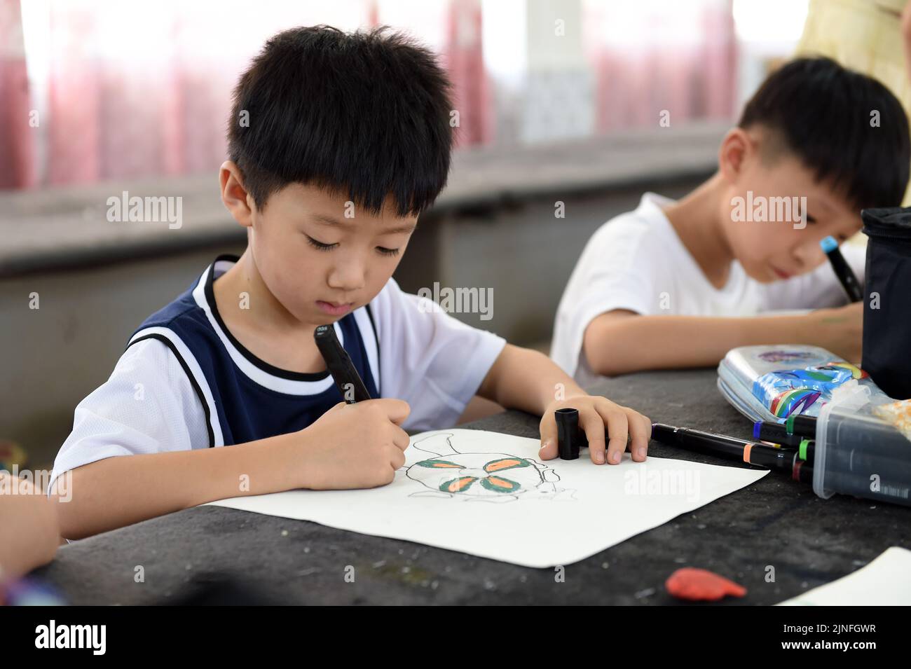 (220811) -- HEFEI, 11. August 2022 (Xinhua) -- Schüler lernen Malerei in Hefei, Ostchina, Provinz Anhui, 11. August 2022. Einige Schulen in Hefei bieten in diesem Sommer kostenlose Kindertagesstätten für Schüler an. Die Kindertagesstätten helfen nicht nur, die Sommerzeit der Schüler zu bereichern, sondern auch, den Druck auf berufstätige Eltern zu lockern, die sich sonst während der Ferien um ihre Kinder kümmern müssen. (Xinhua/Zhou Mu) Stockfoto