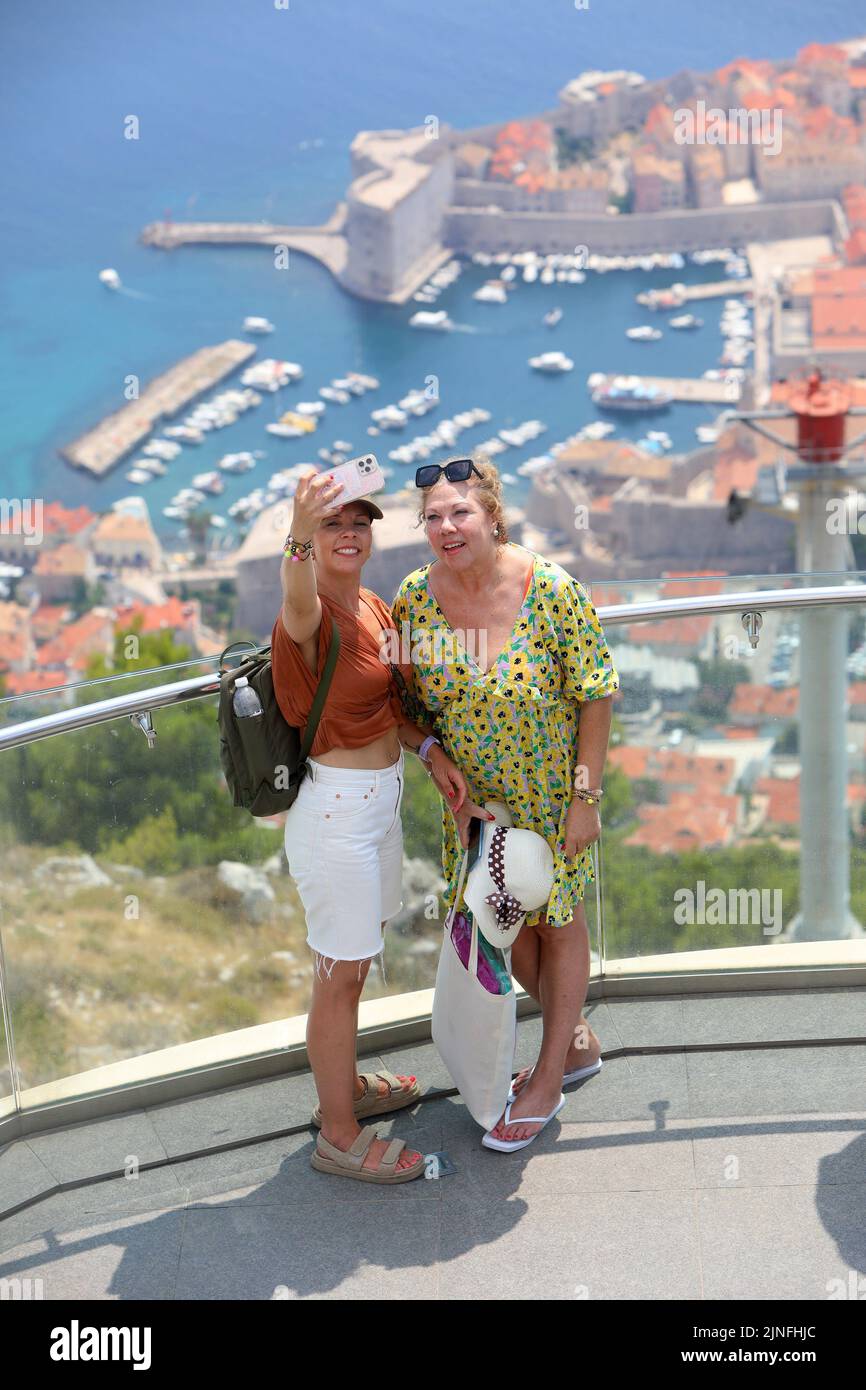 Zahlreiche Touristen kommen mit der Seilbahn auf den Srdj Hügel, wo sie am 11. August 2022 einen schönen Blick auf Dubrovnik, Kroatien, genießen. Stockfoto