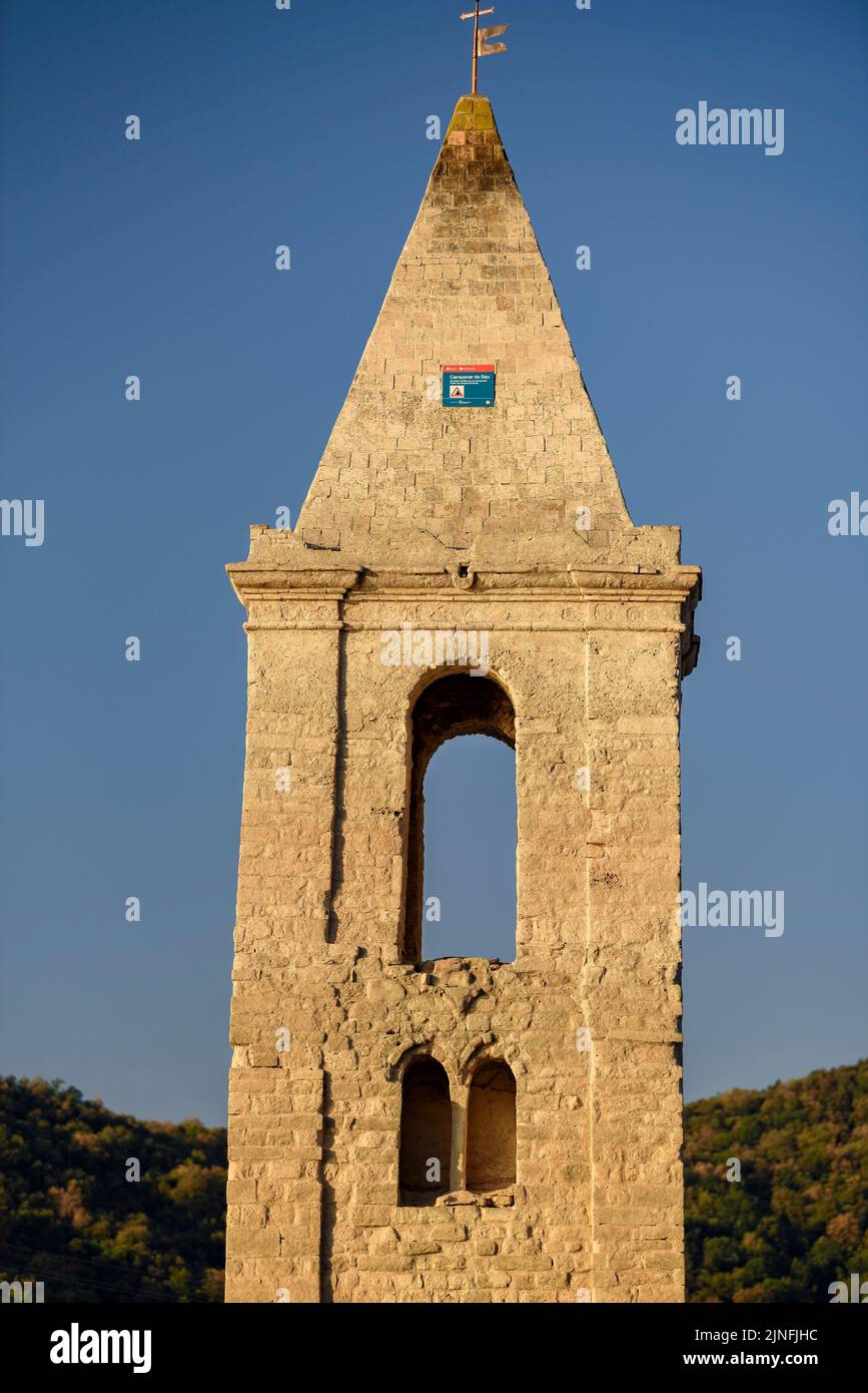 Sonnenaufgang am Glockenturm von Sant Romà de Sau und dem Stausee Sau während der Sommertrockenheit von 2022 (Osona, Barcelona, Katalonien, Spanien) Stockfoto