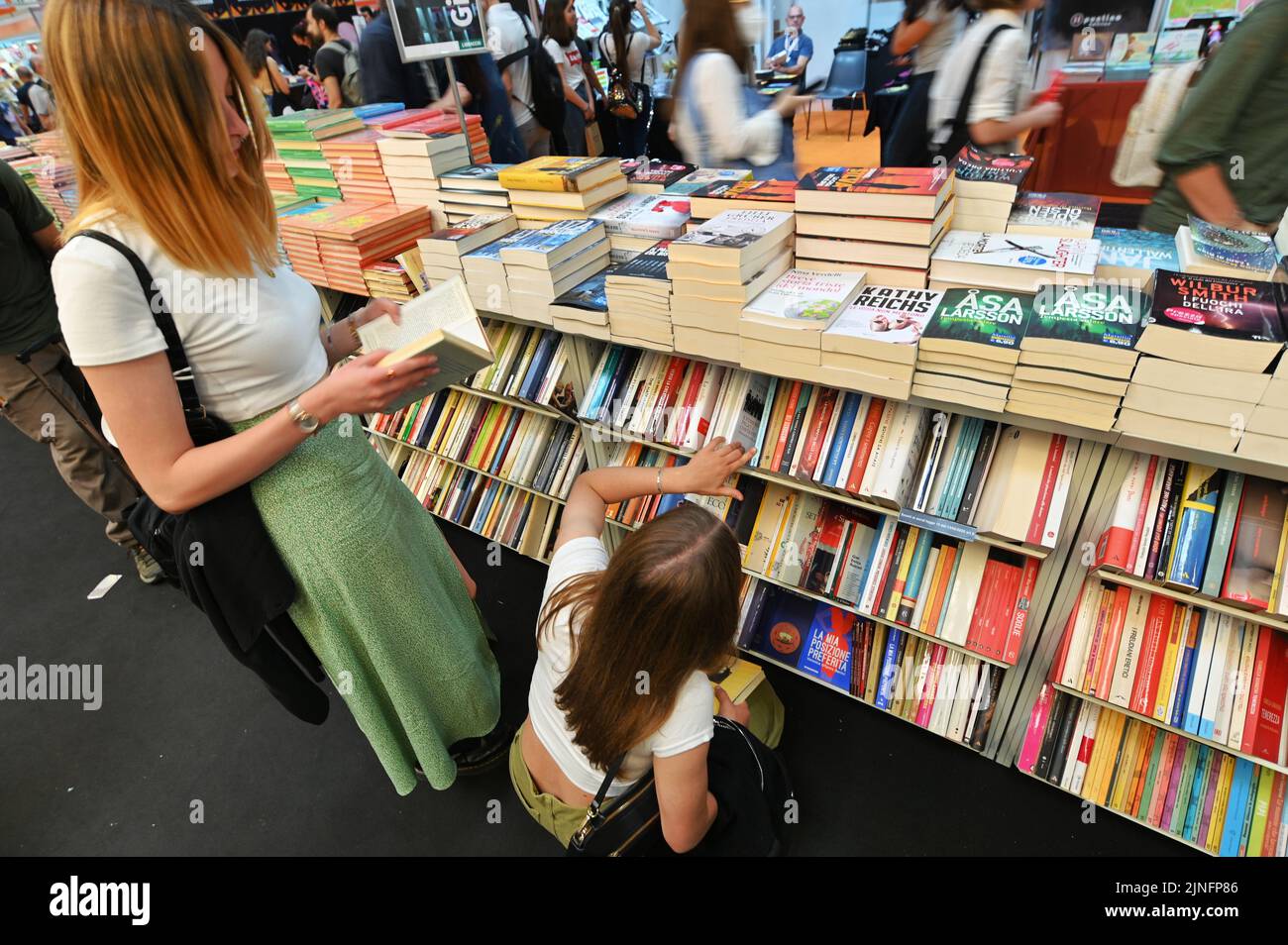 Eine Nahaufnahme von Teenagern, die Bücher aus Regalen im Second-Hand-Buchladen auswählen Stockfoto