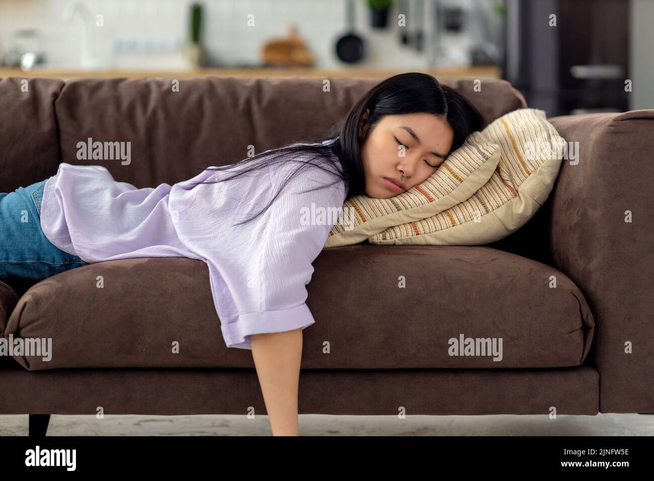 Müde kaukasische junge Frau schläft auf der Couch auf der Couch nach harten Arbeitstag Müdigkeit Konzept Stockfoto