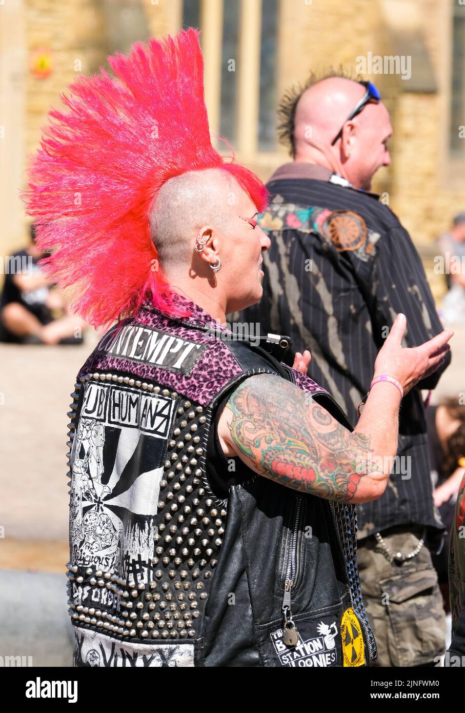 Blackpool, Lancashire, UK August 6 2022 Ein Punk mit leuchtend roten mohikanhaaren und einer Nietenjacke und Tattoos Stockfoto