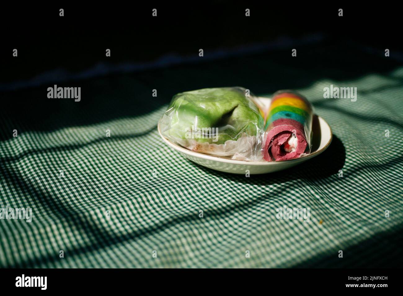 Regenbogen-Rollkuchen mit grünen Boazi auf dem Teller Stockfoto