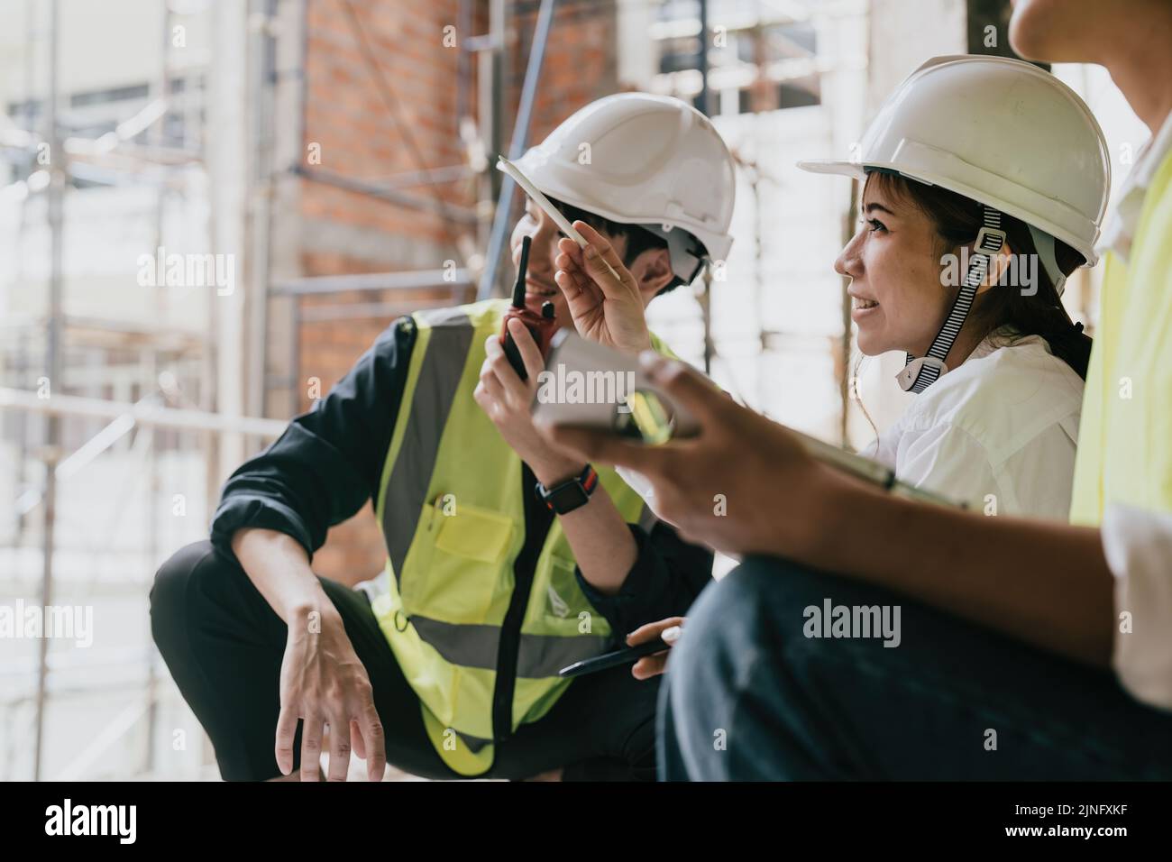Ingenieur und Architekt arbeiten auf der Baustelle mit blauem Druck auf digitalem Taablet. Stockfoto