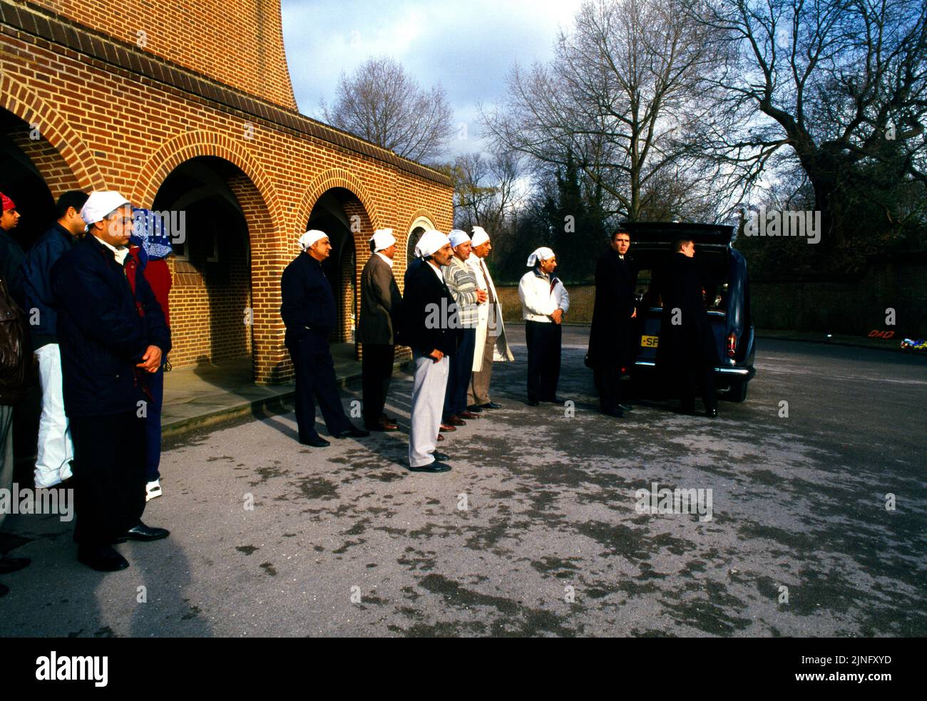 Sikh Funeral (Antam Sanskaar) Familie wartet vor dem Krematorium auf die Ankunft des Coffins in England Stockfoto