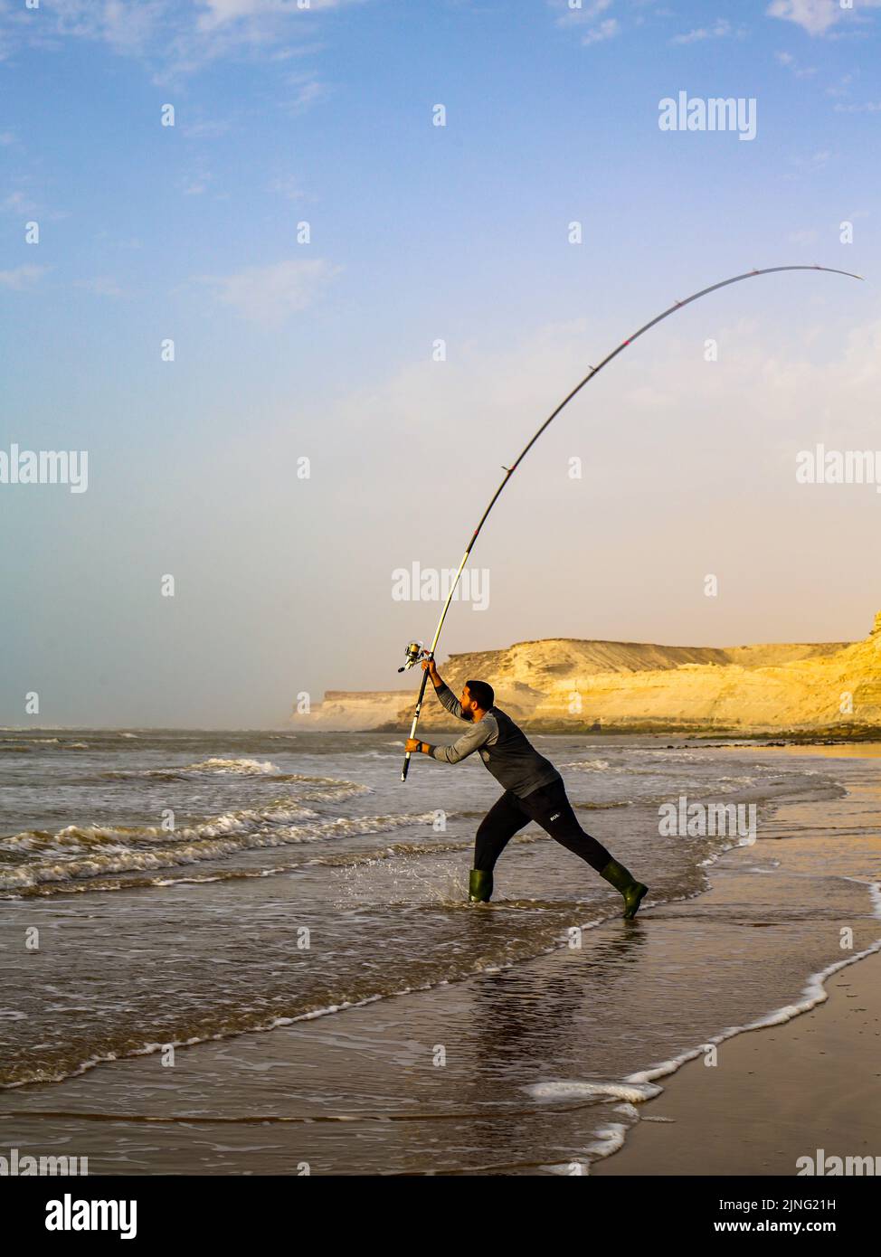 Ein Fischer warf seinen Haken mit seiner Angelrute Stockfoto
